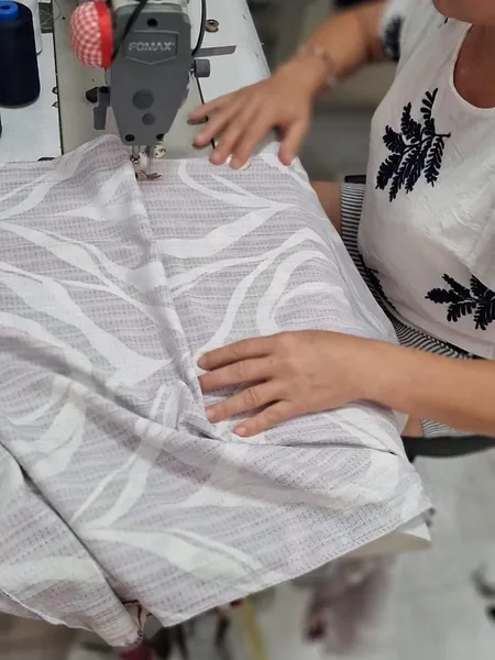 Costurera cosiendo una tela con estampado a máquina