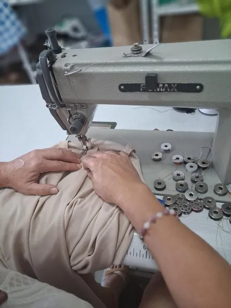 Detalle de manos cosiendo una cremallera a máquina