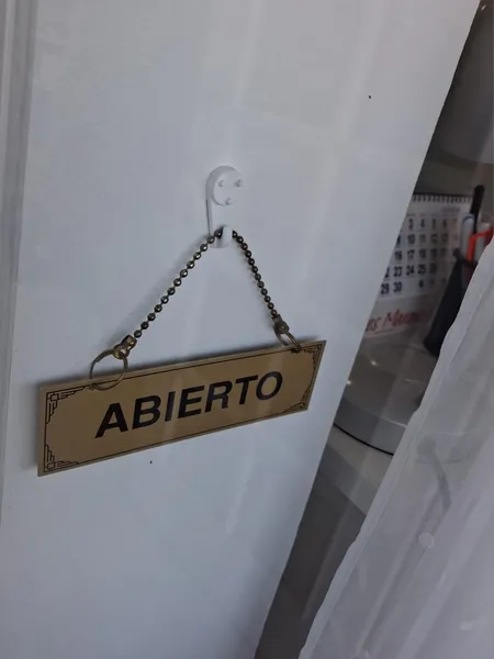 Cartel de "Abierto" en la puerta del taller